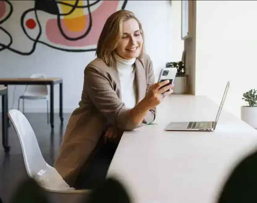 En person med laptop och mobiltelefon deltar i ett digitalt möte.