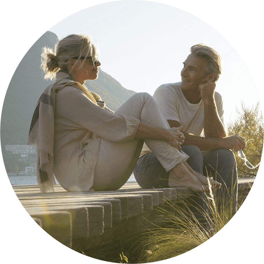 En man och en kvinna pratar på en brygga i solnedgången