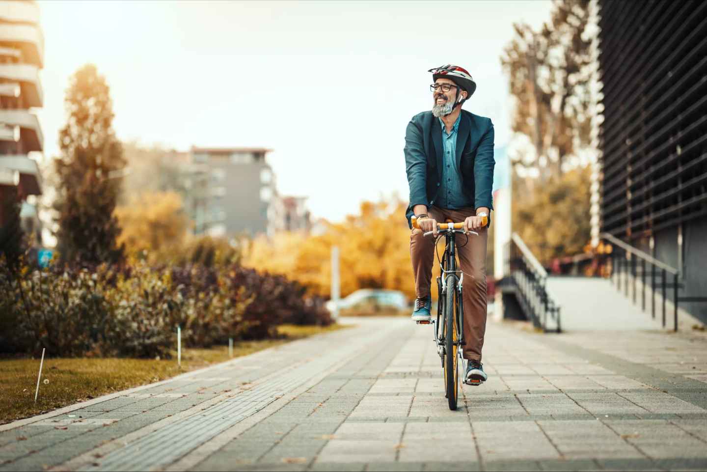 Lycklig cyklist på vägen igenom ett bostadsområde.